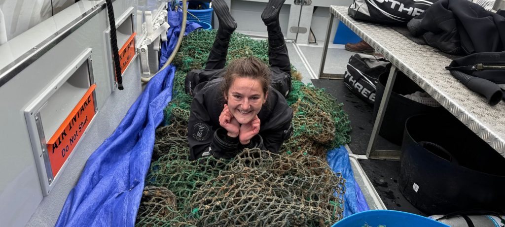 Dr Phoebe Hudson with a ghost net that she helped recover from the ocean.